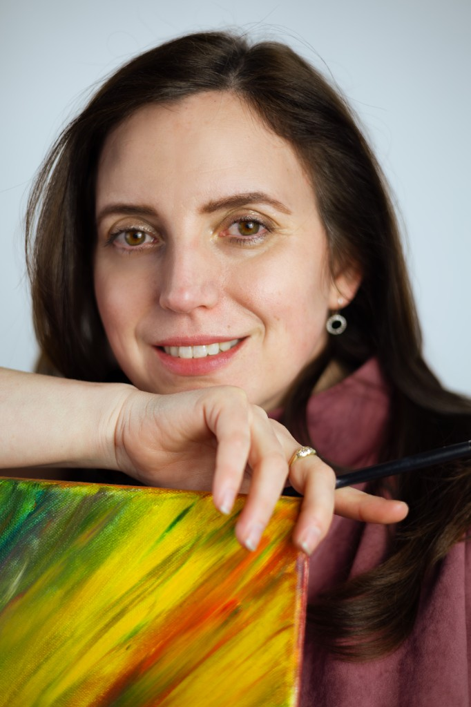 Liana Terec — portret creativ lângă pânză abstractă colorată, cu pensula în mână